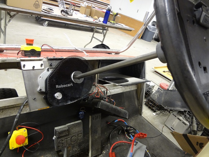 The steering mechanism attached to the golf cart's dash.